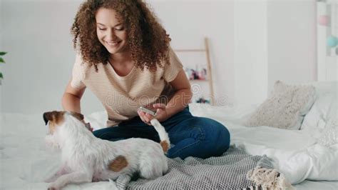 Teenage Girl Having Fun With Her Dog In Bedroom